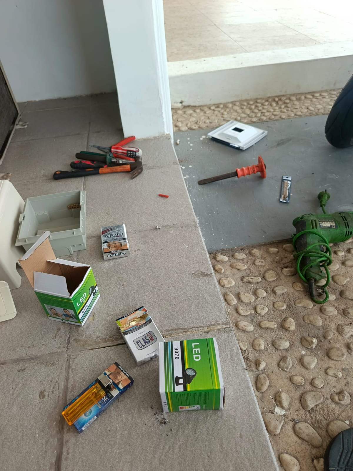 Certified electrician installing an electrical panel and neat wiring, using tester, safety gloves, realistic photo, Indonesian home.